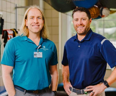 Two men standing in gym