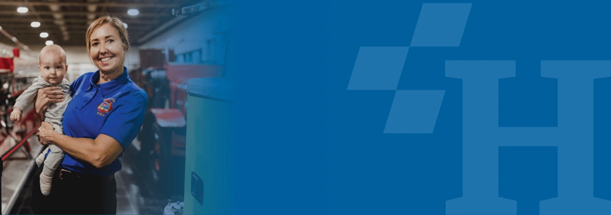 Photo of a smiling woman in a fire department shirt holding a baby, blended with a branded blue background