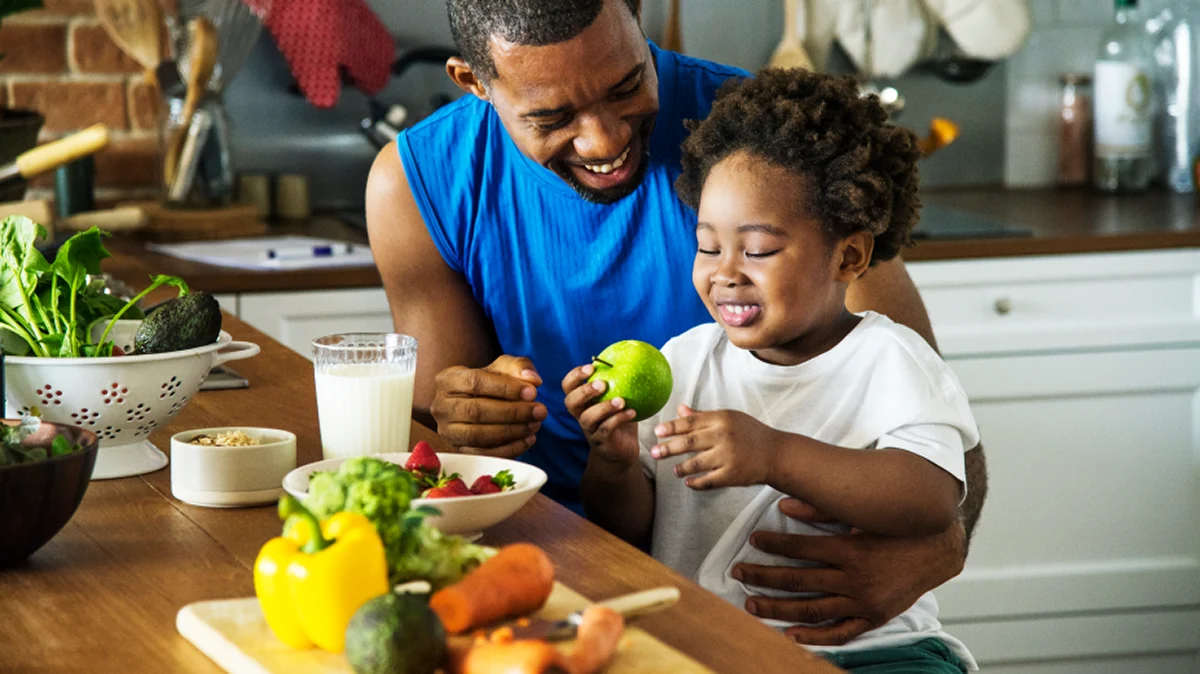 Smiling child and parent enjoying healthy food together – perfect for blog topics around nutrition, sugar intake, or creating healthy habits at home