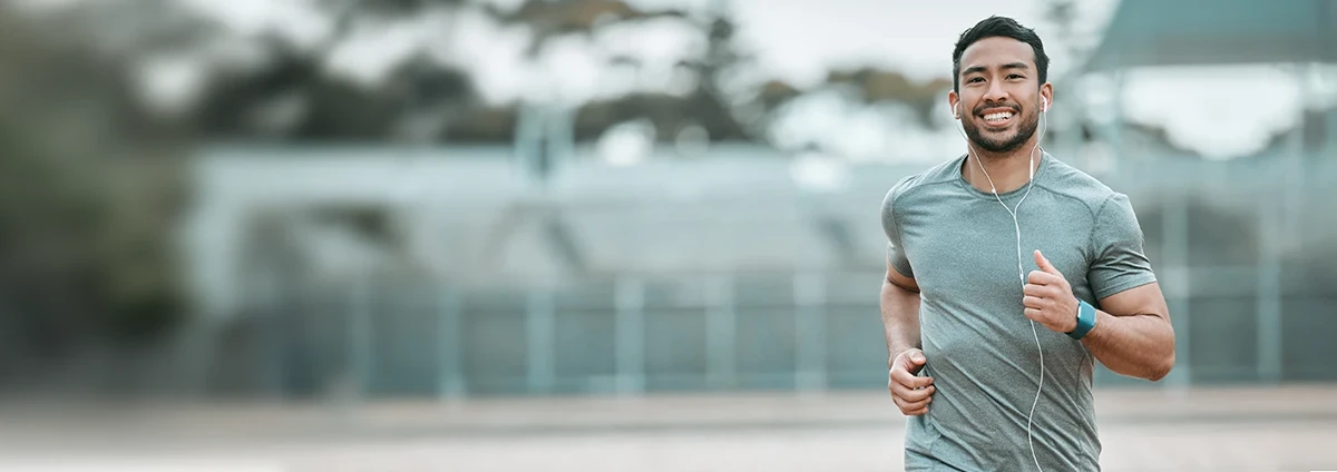 A man jogs outside while wearing headphones.