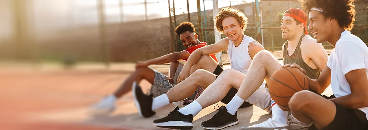Laughing young men play basketball