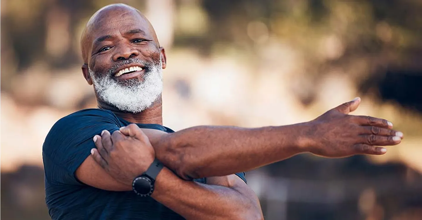 man with beard smiling and stretching his arm